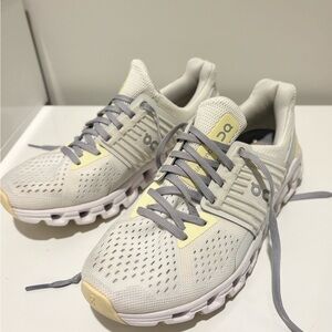 On Running Cream and Yellow Athletic Shoes